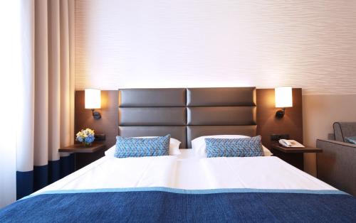 ウィーンにあるドライ クローネン ホテル ウィーン シティのベッドルーム1室(大型ベッド1台、青い枕2つ付)