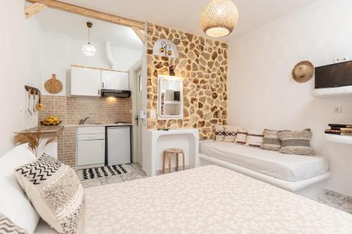 a living room with two beds and a kitchen at Studios Tasia in Agios Prokopios