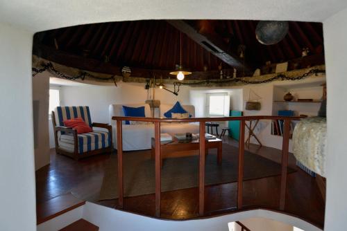 a living room with a table and a bedroom at FLH Moinho do Mar in Ericeira