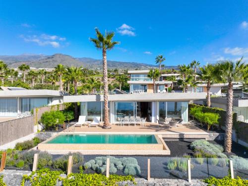 una vista aérea de una casa con piscina y palmeras en Los Jardines de Abama Suites, en Guía de Isora