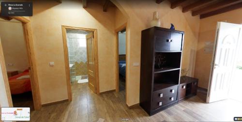 a room with a black cabinet and a bedroom at Finca La Ecarada. Férez (Albacete) in Férez