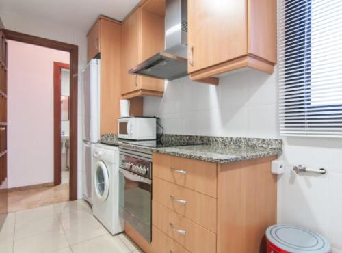 a kitchen with a stove and a microwave at Picasso Suites in Barcelona