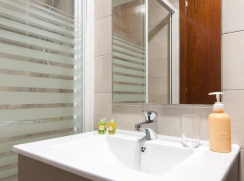 a bathroom with a sink and a mirror at Picasso Suites in Barcelona
