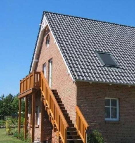 a brick house with a staircase and a roof at Rügen-Fewo 175 in Blieschow