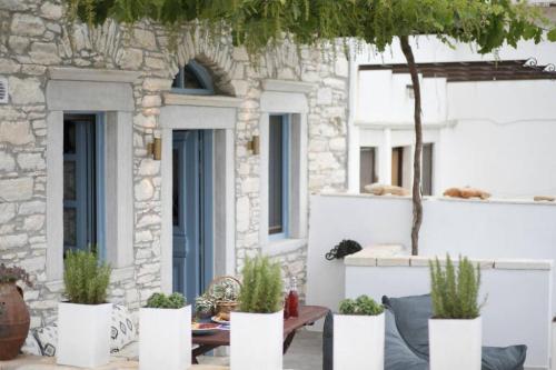 a patio with potted plants in front of a building at Traditional Inn Pirethron in Apeiranthos