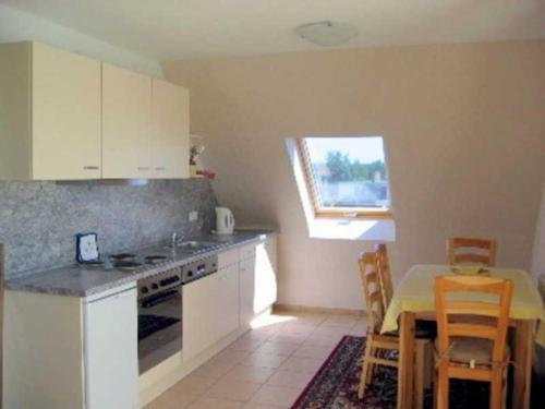 a kitchen with white cabinets and a table and a window at Rügen-Fewo 175 in Blieschow