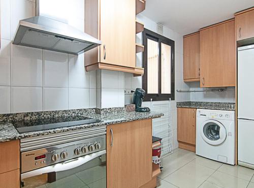 a kitchen with a stove and a washer and dryer at Picasso Suites in Barcelona