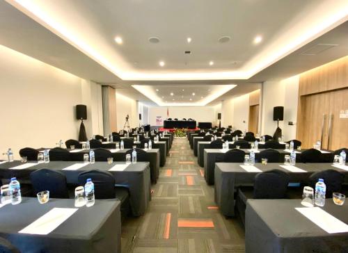 a room filled with tables and chairs with water bottles at Grand Zuri Malioboro in Yogyakarta