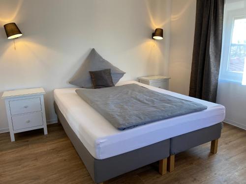 ein Bett in einem Schlafzimmer mit zwei Nachttischen und zwei Lampen in der Unterkunft Villa Quintana in Künzing