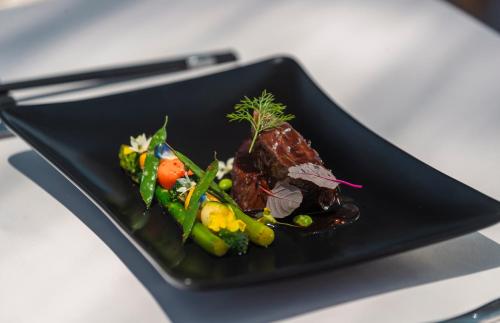 a black plate of food on a table at Furaveri Maldives - COMPLIMENTARY ROUND-TRIP SEAPLANE TRANSFER for two for a minimum of 5 nights or more from May 1st to October 31st, 2025 in Raa Atoll