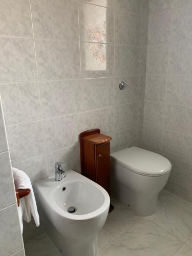 Baño blanco con aseo y lavamanos en B&B Bentu de Mari, en Villasimius