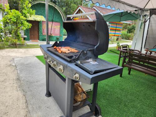a barbecue grill with food cooking on top of it at Genting Greenwoods Tiny Houses & Events Hall in Genting Highlands