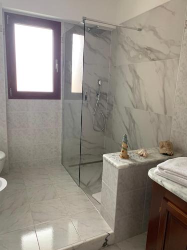 baño con ducha y puerta de cristal en B&B Bentu de Mari, en Villasimius
