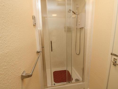 a shower with a glass door in a bathroom at Netherscar in Weathercote