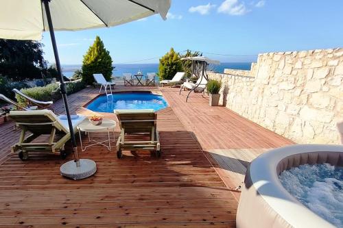 a patio with a pool and chairs and an umbrella at Pamela's house "private pool and spa" in Karteros