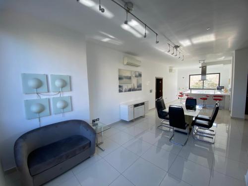 a living room with a couch and a table and chairs at Lemon Tree Residence in Amman