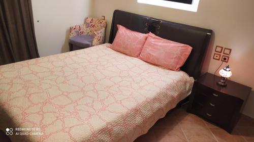1 dormitorio con 1 cama con almohadas rosas en Theodora's home, en Citera