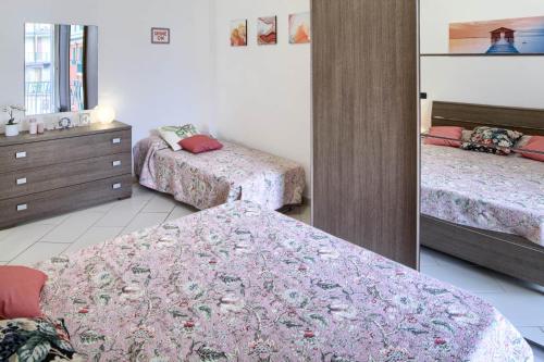 um quarto com 3 camas, uma cómoda e um espelho em Fernanda 2 em Levanto