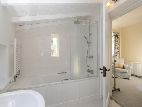 a white bathroom with a tub and a sink at Glenconner Garden Cottage in North Berwick