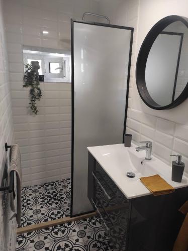 a bathroom with a sink and a mirror and a shower at Garitsa Apartments B in Agios Rokkos
