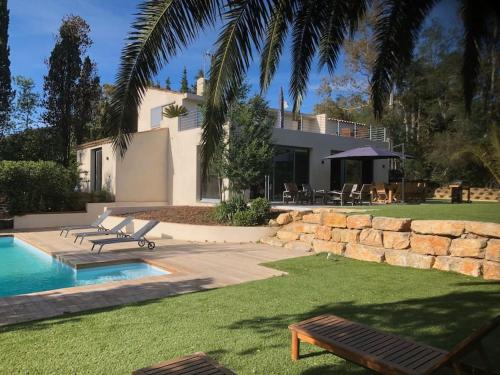 a home with a swimming pool and a house at Villa de standing dans le Golfe de Saint-Tropez in Grimaud