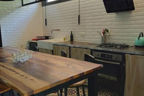 - une cuisine avec une table en bois et une cuisinière dans l'établissement Maison Nadaud avec parking privé, à Mont-de-Marsan