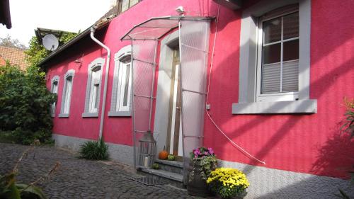 a red building with a door and a window at Winzeranwesen - Weingut Christian Eberley - Haupthaus I MINDESTAUFENTHALT 4 NÄCHTE - MINIMUM STAY 4 NIGHTS in Neustadt an der Weinstraße