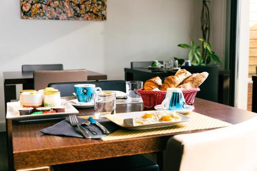 a table with a breakfast of eggs and bread at Hype Hôtel in Biscarrosse