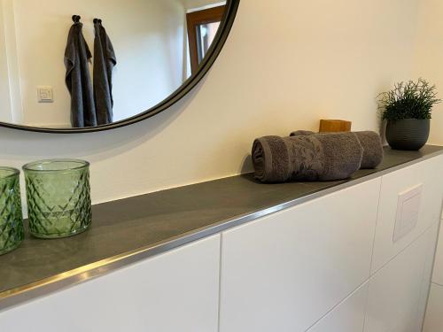 a bathroom counter with a mirror and towels at Rönkhausen Appartements in Finnentrop