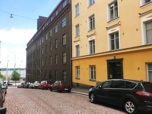 uma rua com carros estacionados ao lado de um edifício em Elegant city home two blocks from Senate Square. em Helsinque