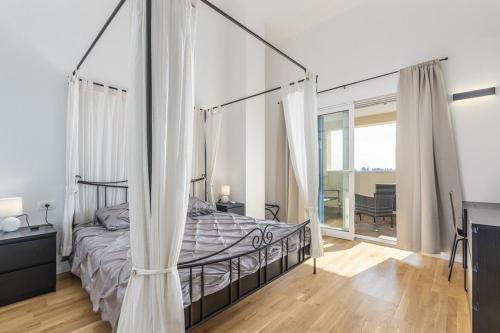 ein Schlafzimmer mit einem Himmelbett und einem großen Fenster in der Unterkunft Sea Villas Residence in Lovrečica