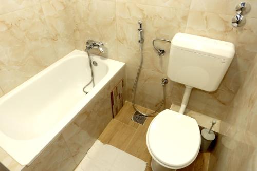 a bathroom with a toilet and a sink and a tub at Pansion Kipovi in Tuzla