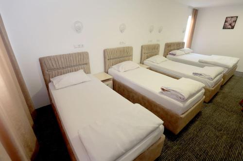 a group of three beds in a room at Pansion Kipovi in Tuzla