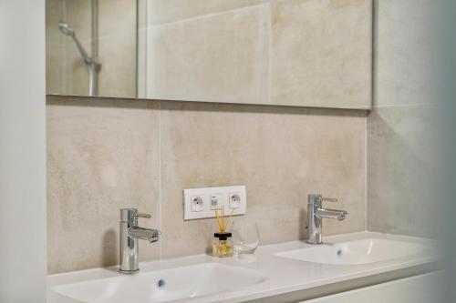 a bathroom with two sinks and a mirror at Holidayhouse Kongé, a place that you call home! in Bruges