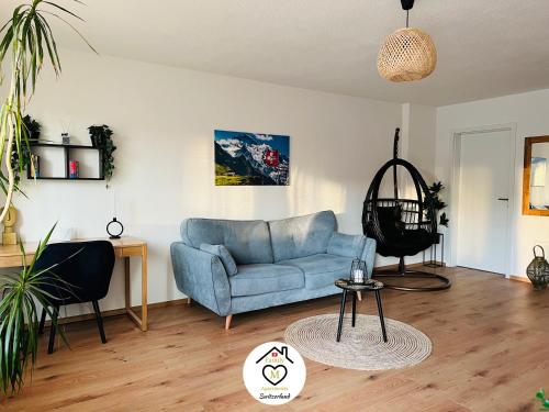 a living room with a blue couch and a table at Family M Apartments 4-5-6 in Kappel bei Olten