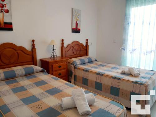 1 dormitorio con 2 camas y 1 mesa con ventana en Apartamento Apolo XVII 22 - Grupo Turis, en Calpe