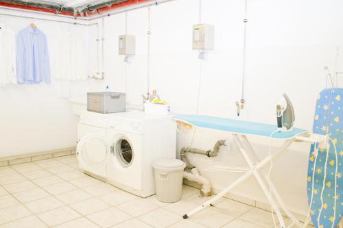 una lavanderia con lavatrice e lavandino di Schweigerhof a Ismaning