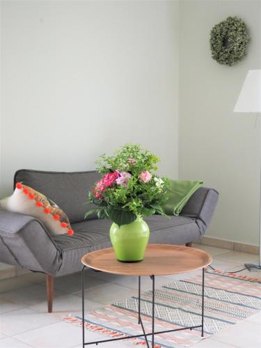 a green vase with flowers on a table in a living room at Schickes Wohnstudio mit Garten am Aasee in Ibbenbüren