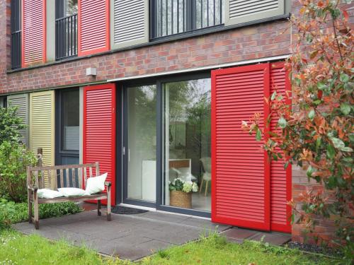a red building with a bench in front of it at Schickes Wohnstudio mit Garten am Aasee in Ibbenbüren