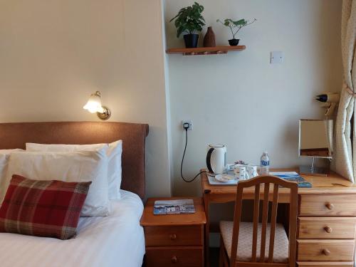 a bedroom with a bed and a desk and a chair at The Norwood in Torquay