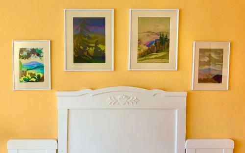 a fireplace with four pictures on a wall at Haus am Kurpark in Schömberg