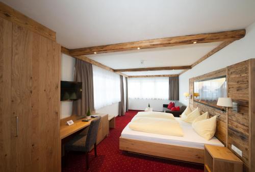 a hotel room with a bed and a desk at Grossarler Panorama Stube in Grossarl