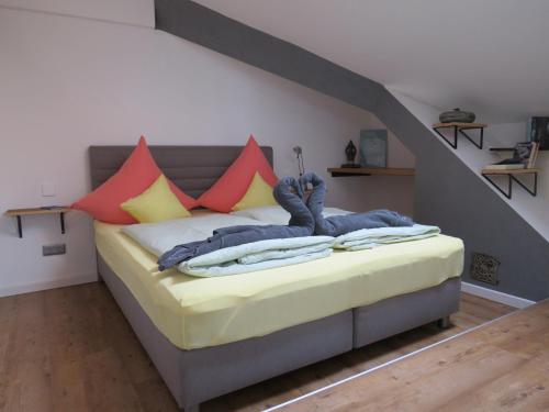 a bedroom with a bed with colorful pillows at Ferienwohnung Lichtspiel - a58017 in Peiting