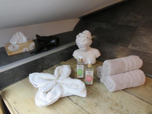 a shelf with towels and a statue and a towel roll at Ferienwohnung Lichtspiel - a58017 in Peiting