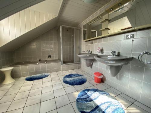 La salle de bains est pourvue d'un lavabo, d'un miroir et d'une baignoire. dans l'établissement Ferienwohnung-Kylltal-Blick, à Gönnersdorf
