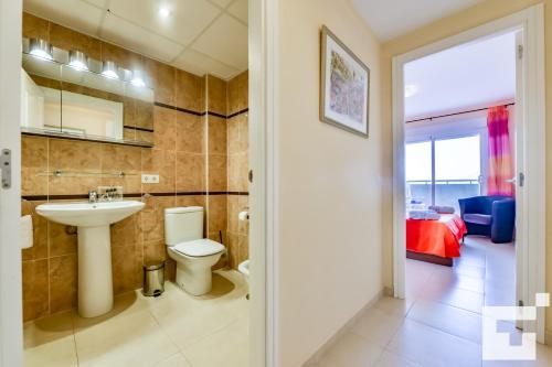 a bathroom with a sink and a toilet and a bedroom at Apartamento Apolo XVIII 59 - Grupo Turis in Calpe