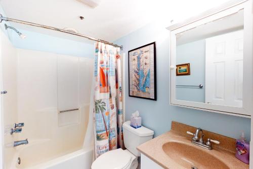 a bathroom with a sink and a toilet and a mirror at Sandpiper Dunes 109 in Ocean City