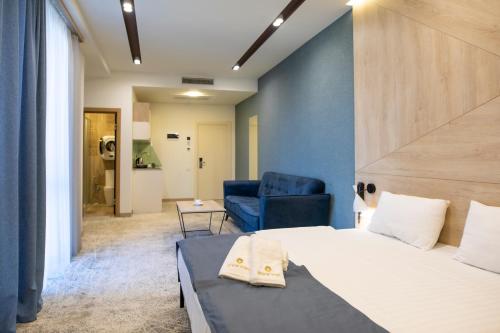 a bedroom with a bed and a blue chair at Rooftop Apart-Hotel in Yerevan