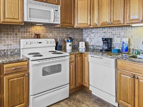 a kitchen with white appliances and wooden cabinets at ML358 Calm And Comfortable Quick Access To Trails WiFi Parking in Snowshoe