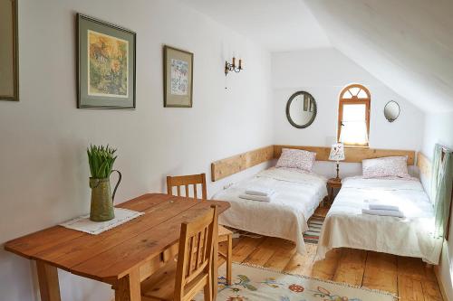 um quarto com 2 camas e uma mesa de madeira em Dom Geologa em Marianówka